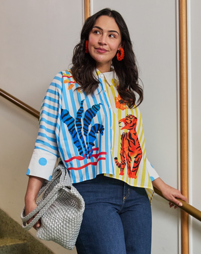 Woman in a striped shirt with tiger print and silver woven tote